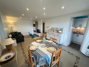 A compact living space with a dining area, kitchenette, and a sofa in the living room. - Apartment with balcony, sea view - 4 guests (Cabourg)