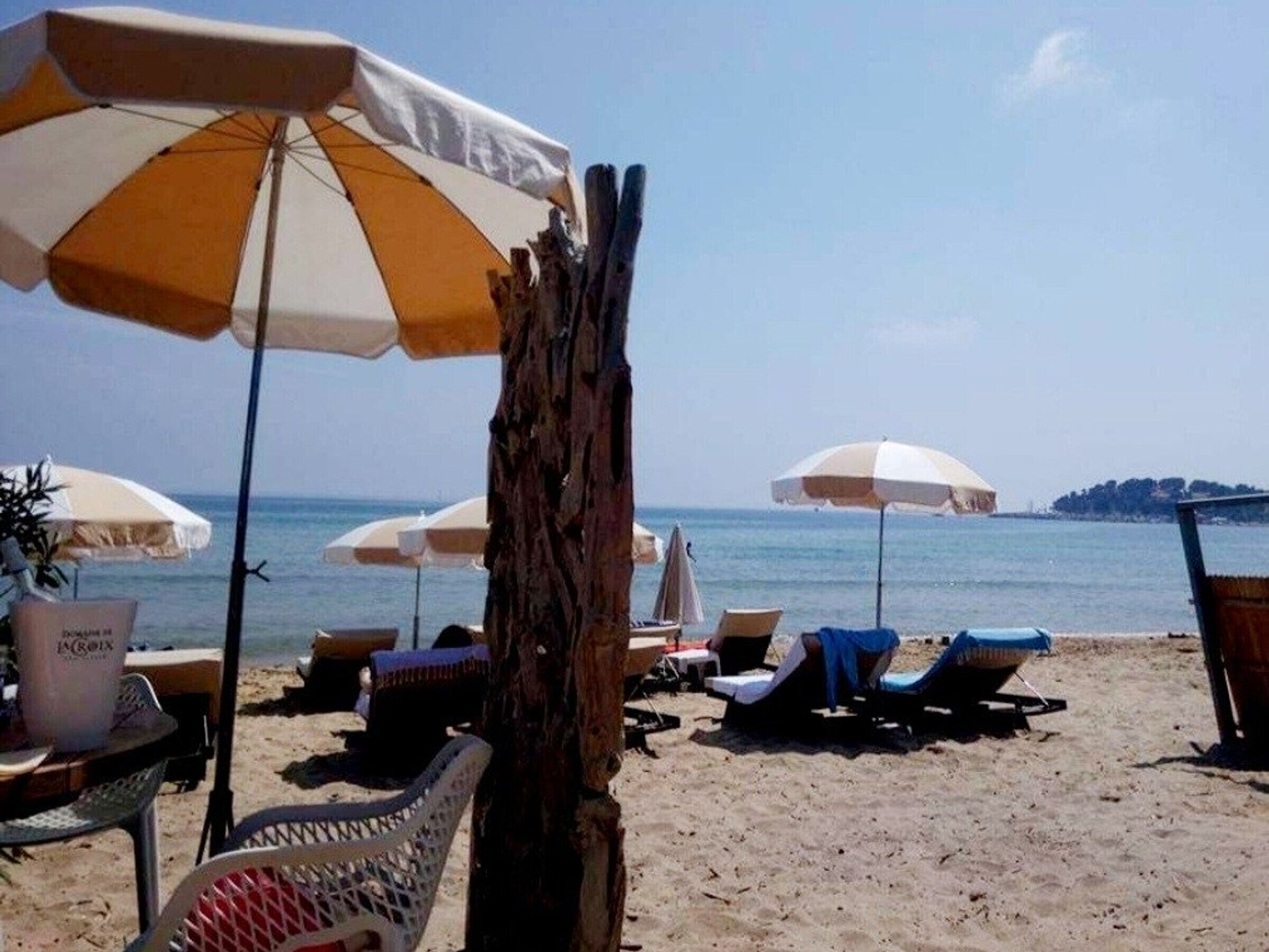 A beach with multiple umbrellas and lounge chairs.