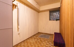 Ein Saunaraum mit Schachbrettboden, einer Sitzbank, einem Fenster mit Milchglas und Holzwänden.
