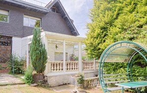 Ein Haus mit Wintergarten, Terrasse und Garten.