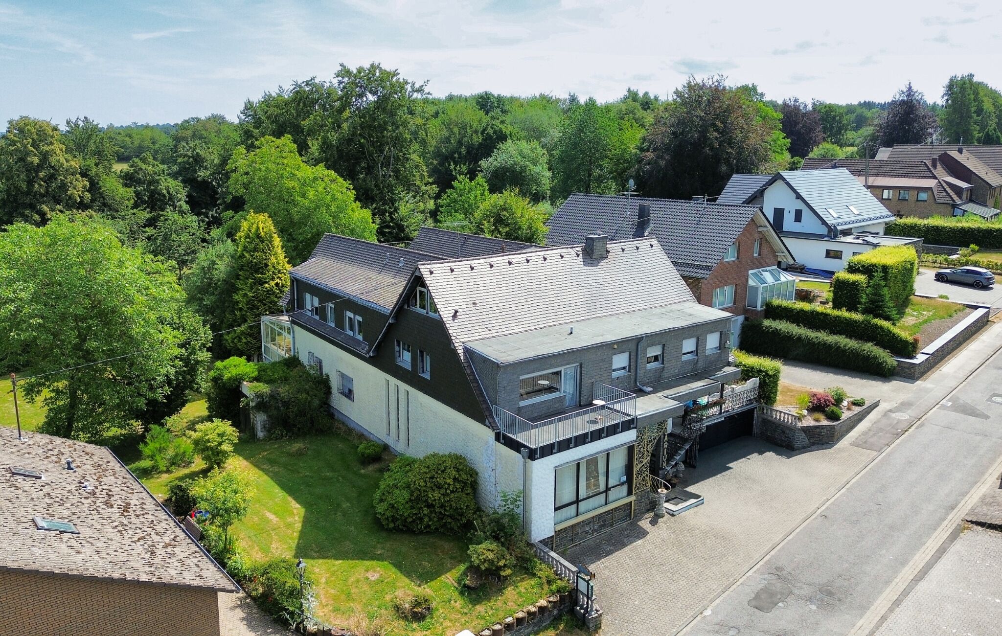 Ein Wohngebiet mit modernen Häusern, einem gepflegten Rasen und blauem Himmel.