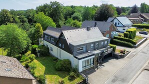 Ett bostadsområde med moderna hus, en välskött gräsmatta och en klar himmel.