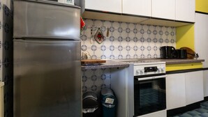 Ett kök med ett kylskåp i rostfritt stål, en spis och en kaffebryggare.