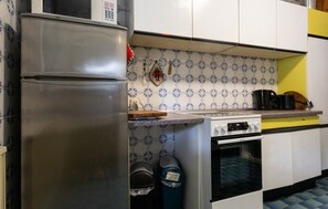 Eine Küche mit einem Edelstahl-Kühlschrank, einem Herd und einer Kaffeemaschine.