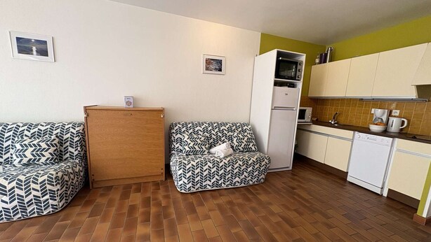 A compact living space with a sofa, a cabinet, a kitchenette, and a microwave. - Calm studio with private parking - 2 guests (Bandol)