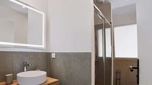 A modern bathroom with a round sink, a mirror, and a shower area. - Renovated apartment mountain view - 2 guests (Saint-Pée-sur-Nivelle)