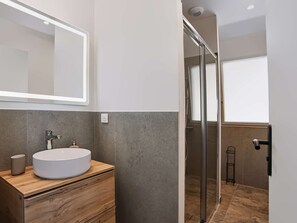 A modern bathroom with a round sink, a mirror, and a shower area. - Renovated apartment mountain view - 2 guests (Saint-Pée-sur-Nivelle)