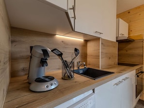 A modern kitchen with a built-in coffee maker, a sink, and a dish rack. - Ski-in/ski-out apartment - 6 guests (Plagne Villages)