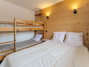 A bunk bed room with wooden walls and two wall-mounted light fixtures. - Ski-in/ski-out apartment - 6 guests (Plagne Villages)