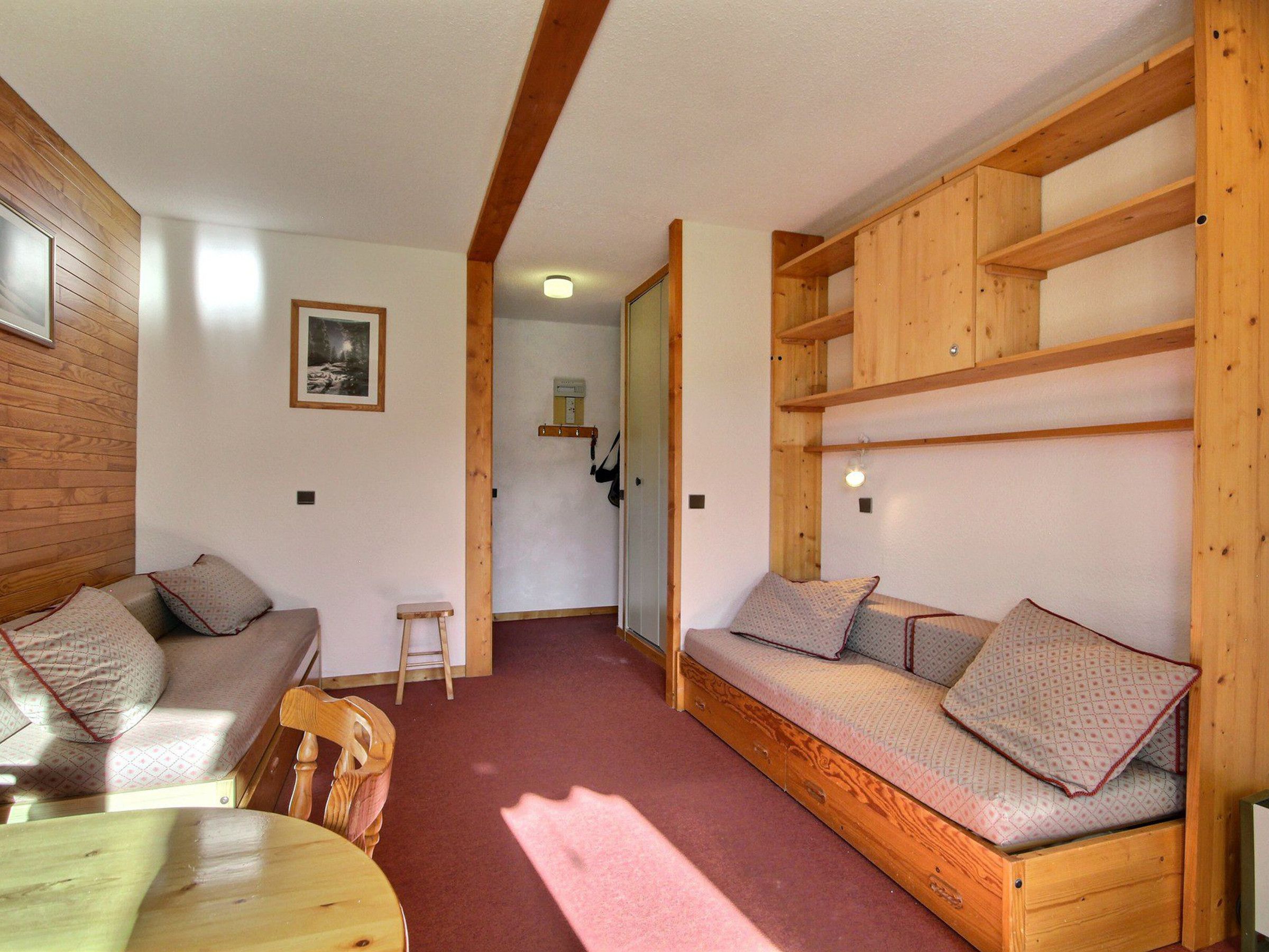 Une pièce de taille modeste, avec un banc en bois, une petite table et une chaise.