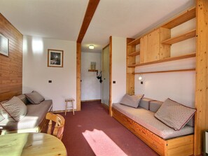 Une pièce de taille modeste, avec un banc en bois, une petite table et une chaise.