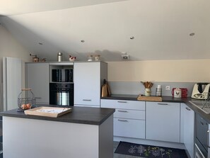 A modern kitchen with a built-in oven, microwave, and a coffee machine. - Quiet apartment near shops - 4 guests (Barcelonnette)