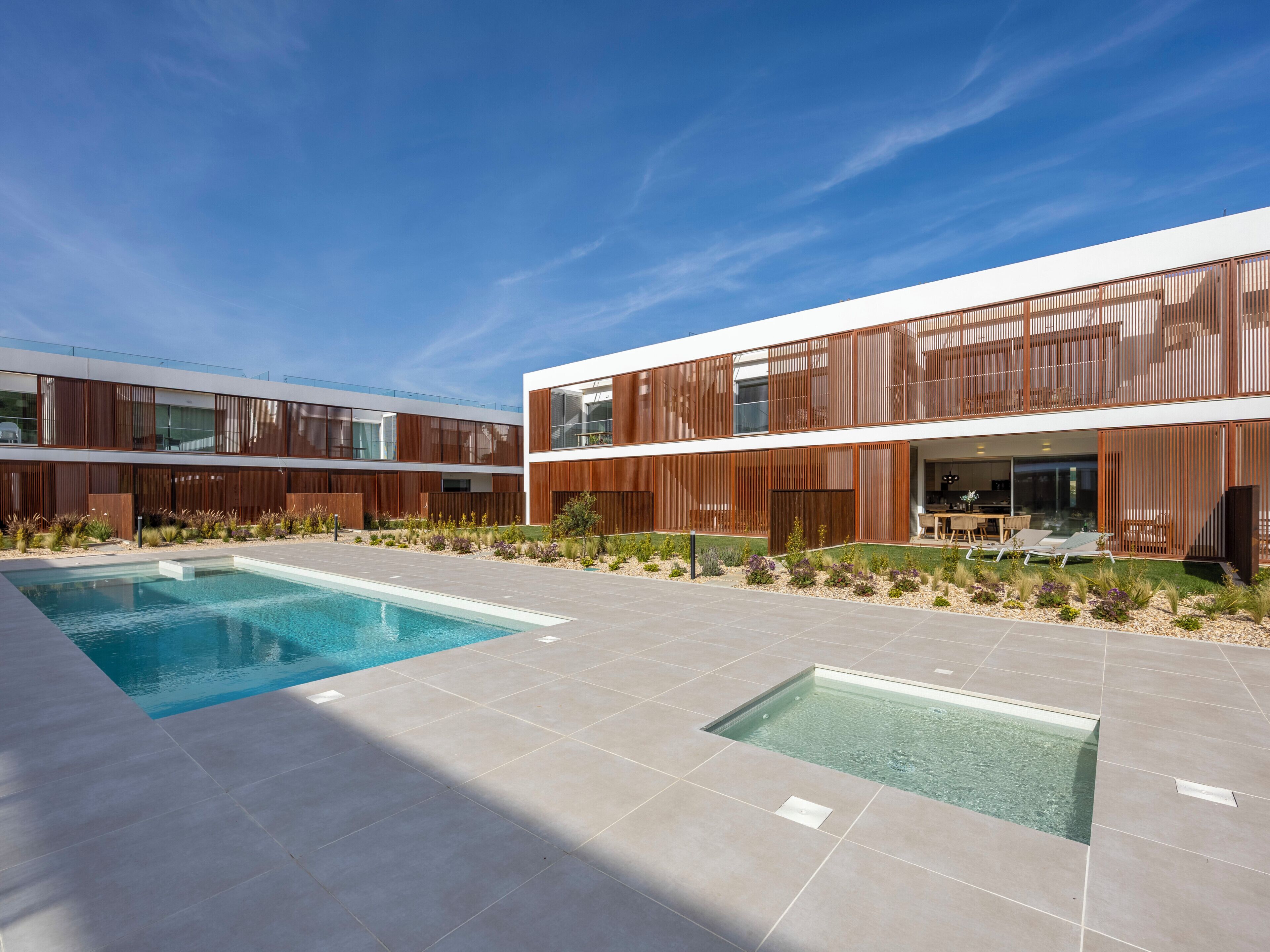 A modern building with a pool and outdoor seating.