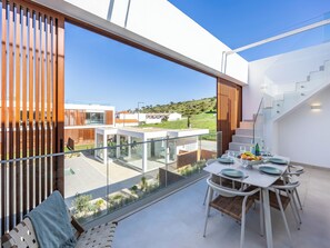 A modern interior with a dining area, large windows, and a view of the surrounding landscape. - Burgau Sea Garden - Cantinho do Mar (Burgau)