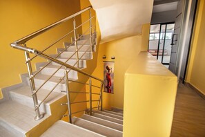 A staircase with metal railings, wooden steps, and a yellow wall. - Villa Banka - Banfelouk Loft - Upper Floor (Dangane)