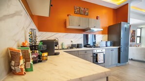 Una cucina moderna con piani di lavoro in marmo, forno integrato e frigorifero grigio.