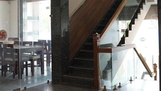 A modern interior with a staircase, glass doors, and a dining area.