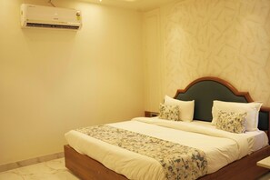 Ein Hotelzimmer mit einem Bett, einer Wand-Klimaanlage und einer Wand mit Muster.