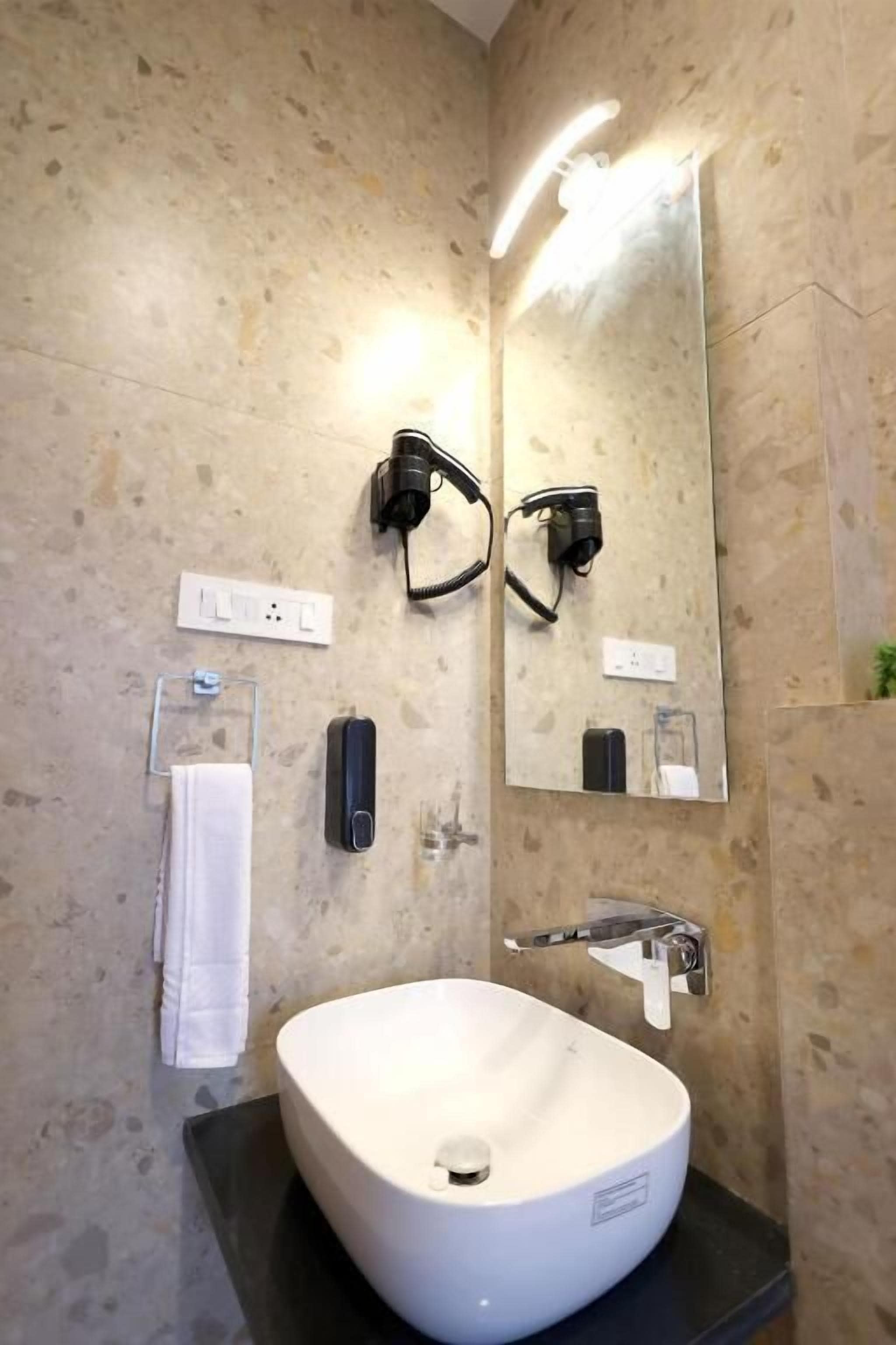 A bathroom with a white sink, a mirror, and a towel rack.