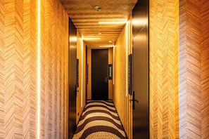 A hallway with a herringbone-patterned wall and a patterned carpet. - Lagos Moments Lodge (Lagos)