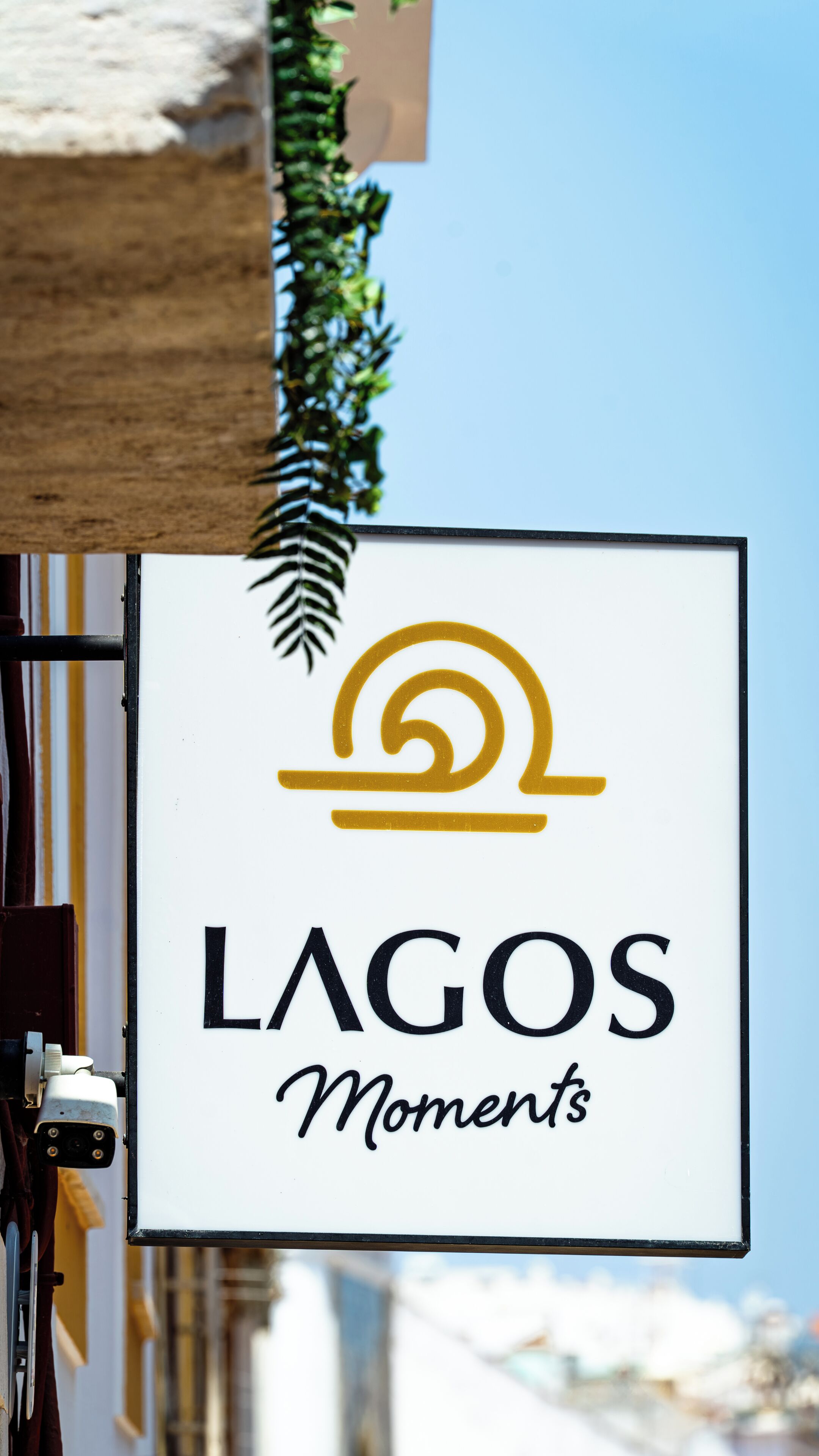 A sign with the text 'LAGOS Moments' and a stylized sun logo.