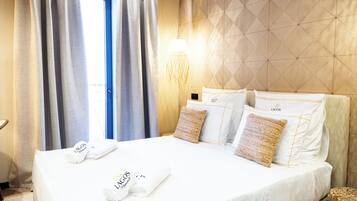 A hotel room with a large bed, a wall-mounted light, and a window with curtains.