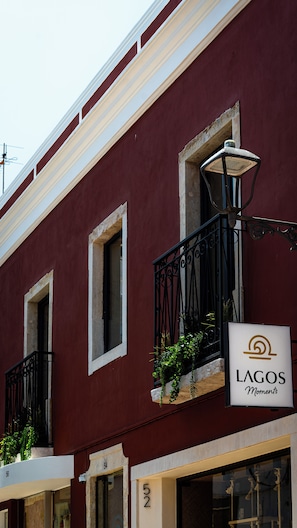 A building facade with a sign reading 'LAGOS Moments' and a balcony with plants.