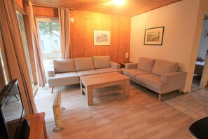A living room with a sectional sofa, a coffee table, and a television. - Schoner Doppelbungalow mit Terrasse im Ferienpark Mirow (Mirow)