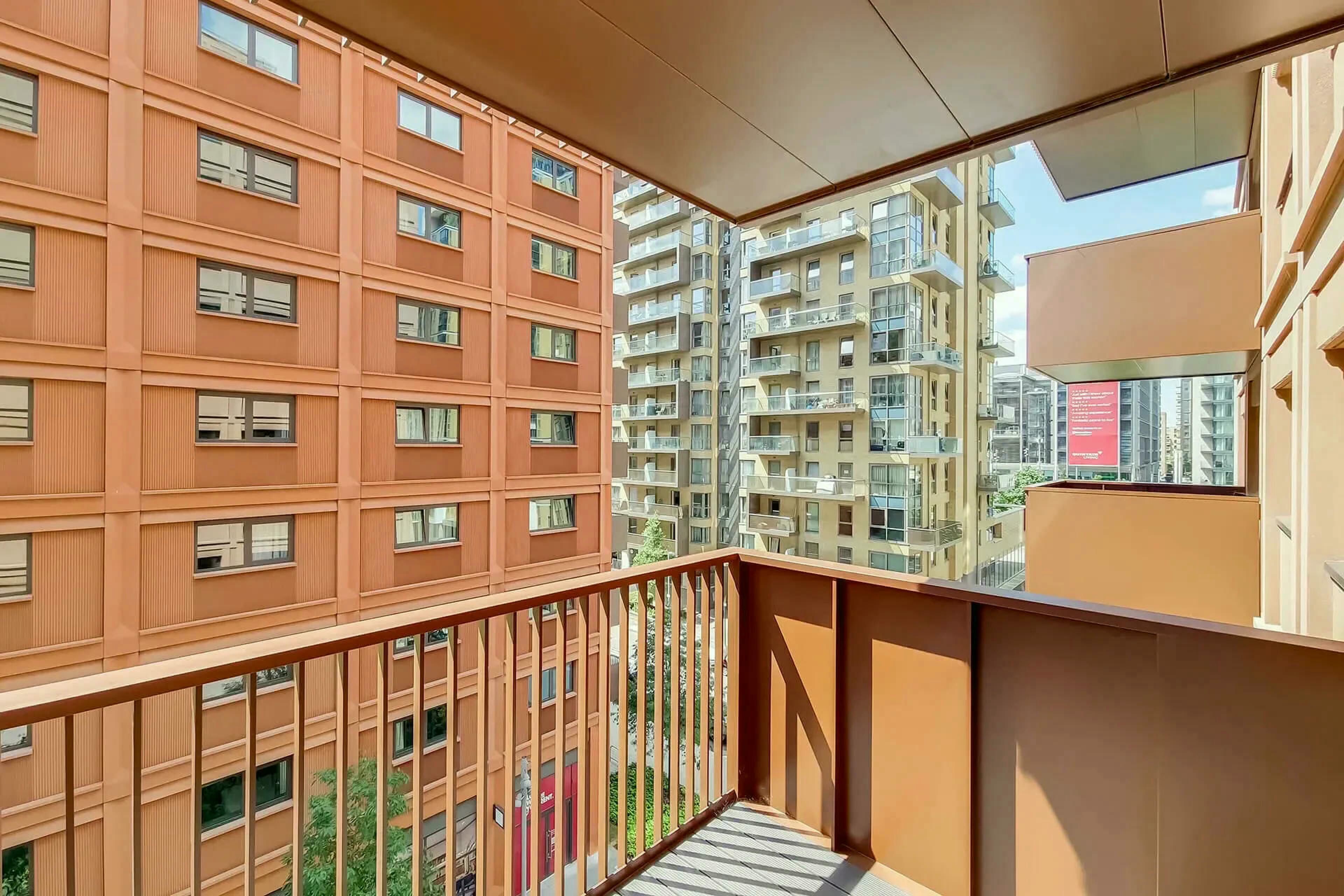 Un edificio residencial de varios pisos con balcones, ventanas amplias y vistas despejadas a edificaciones vecinas.