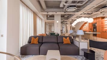 A modern interior with a sectional sofa, a round coffee table, and a bar area with stools.