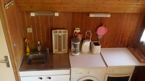 A compact kitchen with a sink, a washing machine, a toaster, and a kettle. - Chalet by Lac des Settons, Private Garden, Near Hiking & Water Activities (Montsauche-les-Settons)