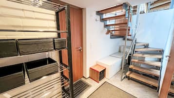 Ein kompakter, moderner Innenraum mit einer eingebauten Sitzbank, einem kleinen Holzschrank und einer Metalltreppe.