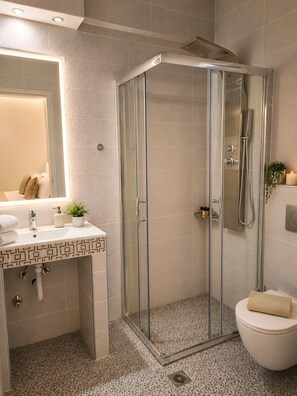 A modern bathroom with a glass-enclosed shower, a sink with a mirror, and a toilet. - Studio Apartment 'Chriss 101' with Sea View, Wi-Fi and Air Conditioning (Skala Sotiros)