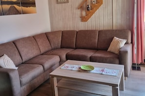 A brown sectional sofa with a wooden coffee table in front. - Gemutlicher Doppelbungalow im Ferienpark Mirow mit Terrasse (Mirow)