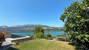 Une cour verdoyante avec vue sur un lac et des montagnes.