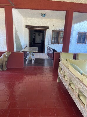 A room with a red brick floor, a white table with chairs, and a wooden bench. - Kizakura Homes-Spacious 6-bedroom Villa in Marine Park. Malindi Kenya (Malindi)