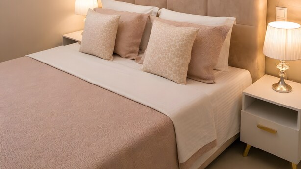 A bedroom with a large bed, two bedside tables with lamps, and a textured wall. - Studio Apartment 'Chrissi 104' with Sea View, Wi-Fi and Air Conditioning (Skala Sotiros)