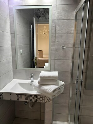 A bathroom with a white sink, a mirror, and a shower. - Studio Apartment 'Chrissi 102' with Sea View, Wi-Fi and Air Conditioning (Skala Sotiros)