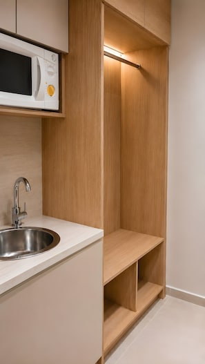A modern kitchen with a built-in microwave, stainless steel sink, and wooden shelving. - Studio Apartment 'Chrissi 103' with Sea View, Wi-Fi and Air Conditioning (Skala Sotiros)