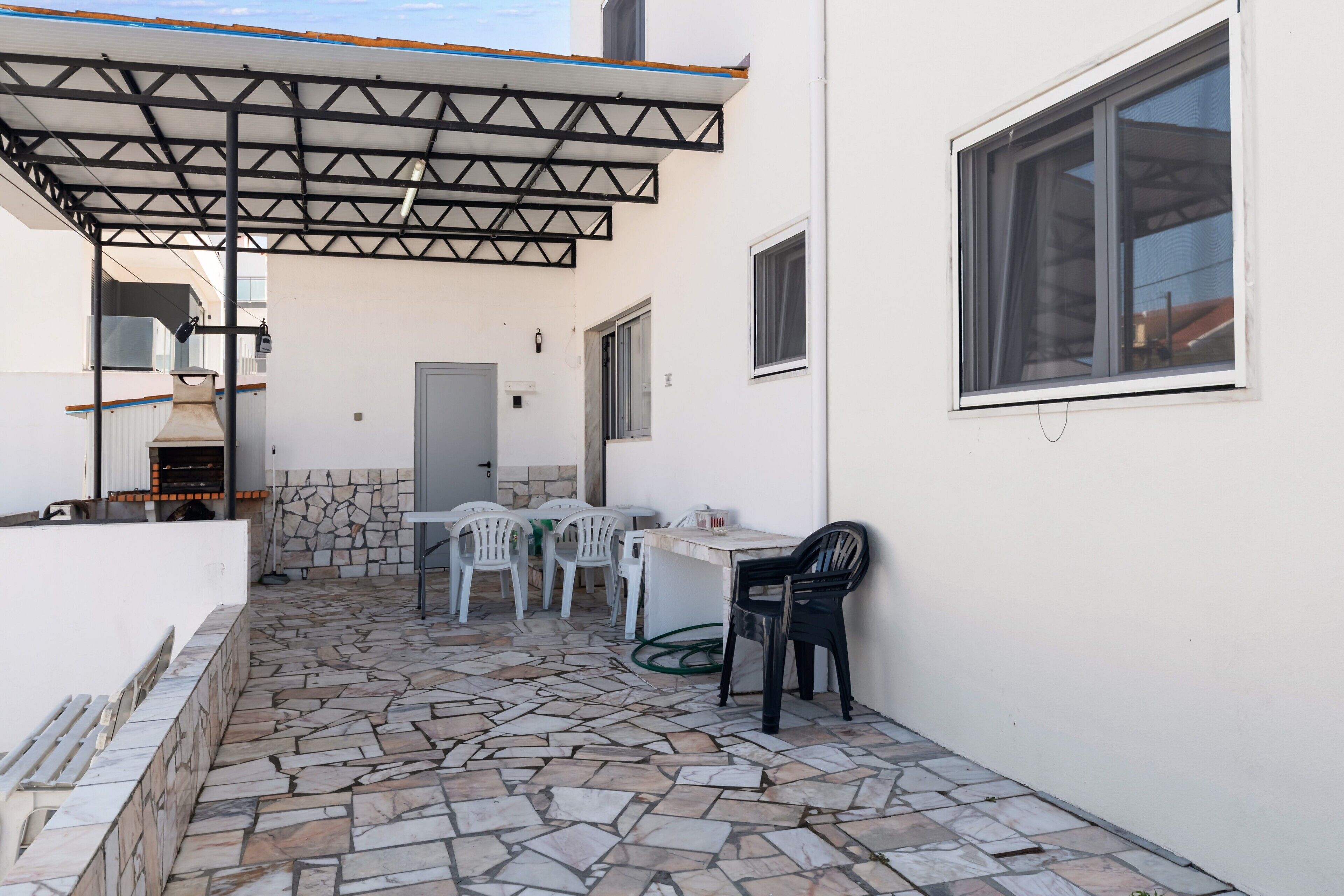 Un espace patio doté d’un sol en pierre, d’un coin salon abrité et d’une fenêtre.