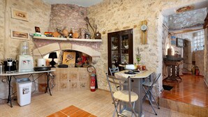 Una cocina rústica con chimenea, una mesa de comedor con sillas y varios electrodomésticos.
