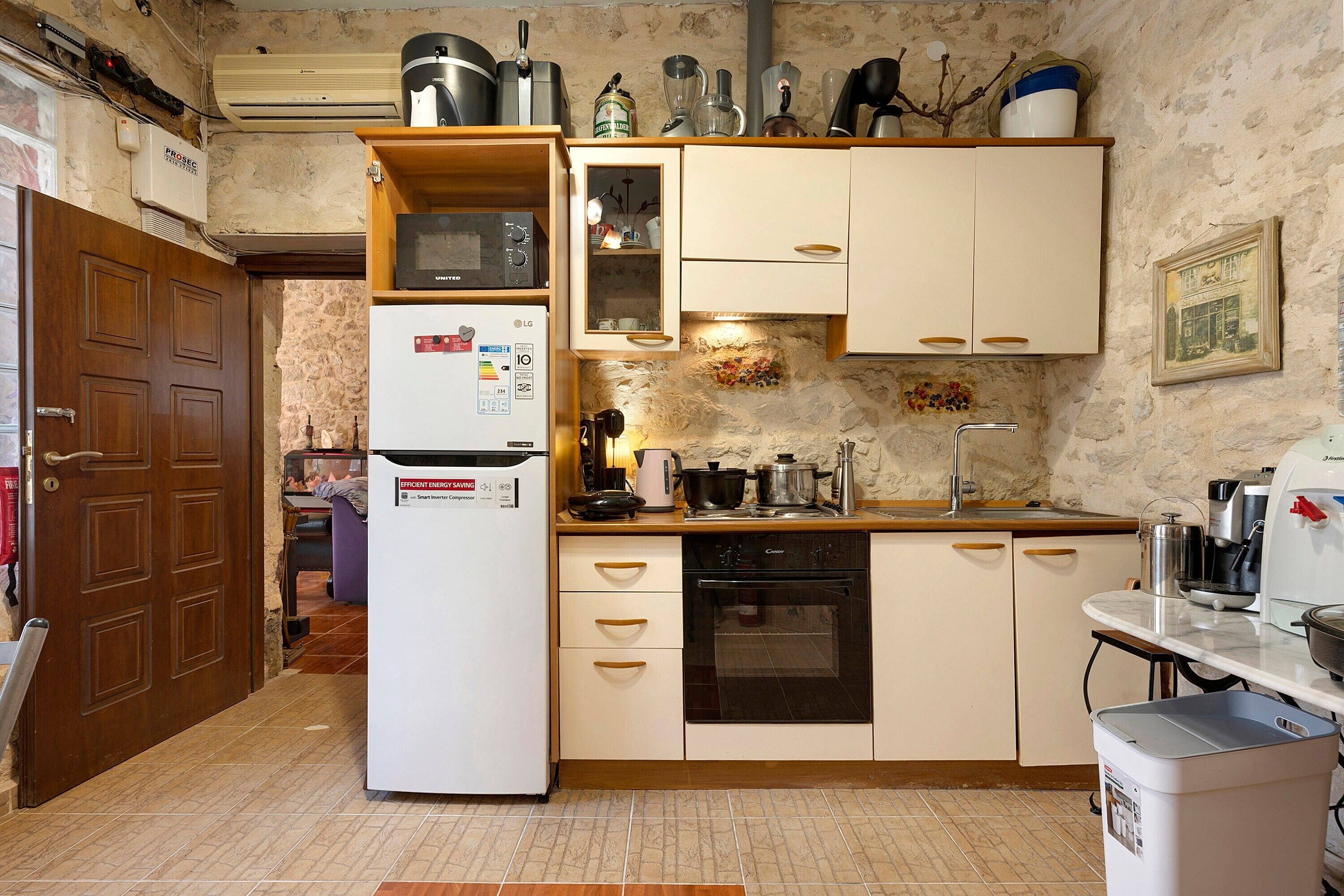Eine Küche mit Kühlschrank, Herd, Backofen und diversen Küchengeräten.