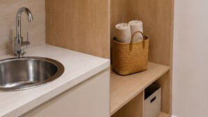 A kitchen with a sink, a microwave, and a wooden storage unit with towels. - Studio Apartment 'Chrissi 105' with Mountain View, Wi-Fi and Air Conditioning (Skala Sotiros)