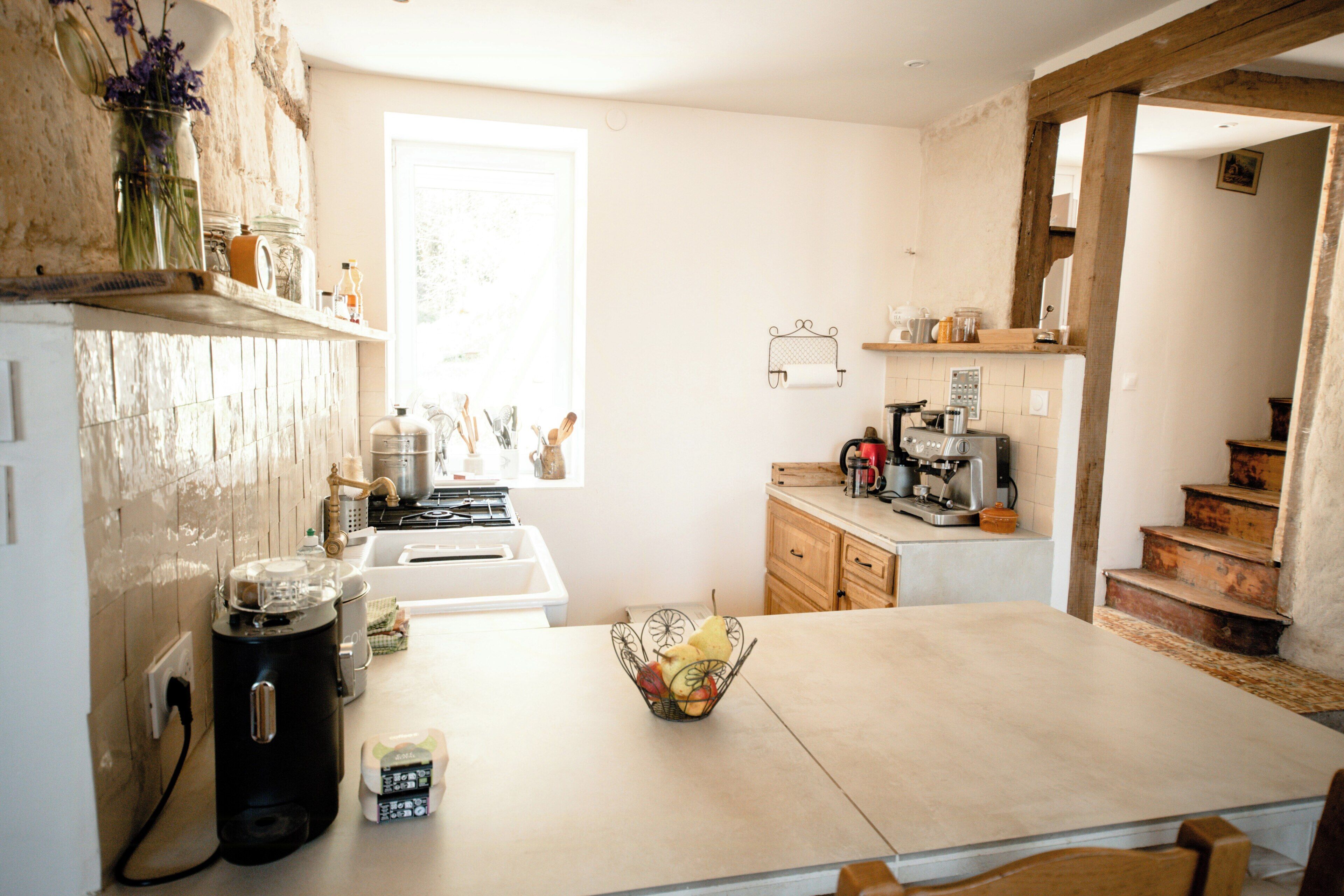 A kitchen with a central island, a stove, and a coffee machine.