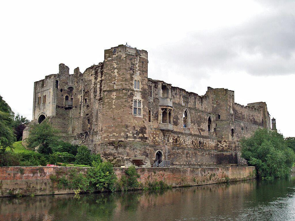 Un château historique situé au bord d’une rivière.
