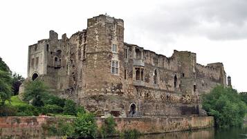 Un château historique situé au bord d’une rivière.