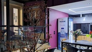 A modern interior with a dining area, a refrigerator, and a view through a glass door. - Mon Ami Boutique Hotel  (Shkoder)