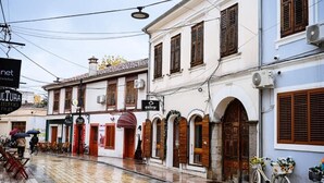A street with buildings, a bicycle, and a sign for 'CULTURA'. - Mon Ami Boutique Hotel  (Shkoder)
