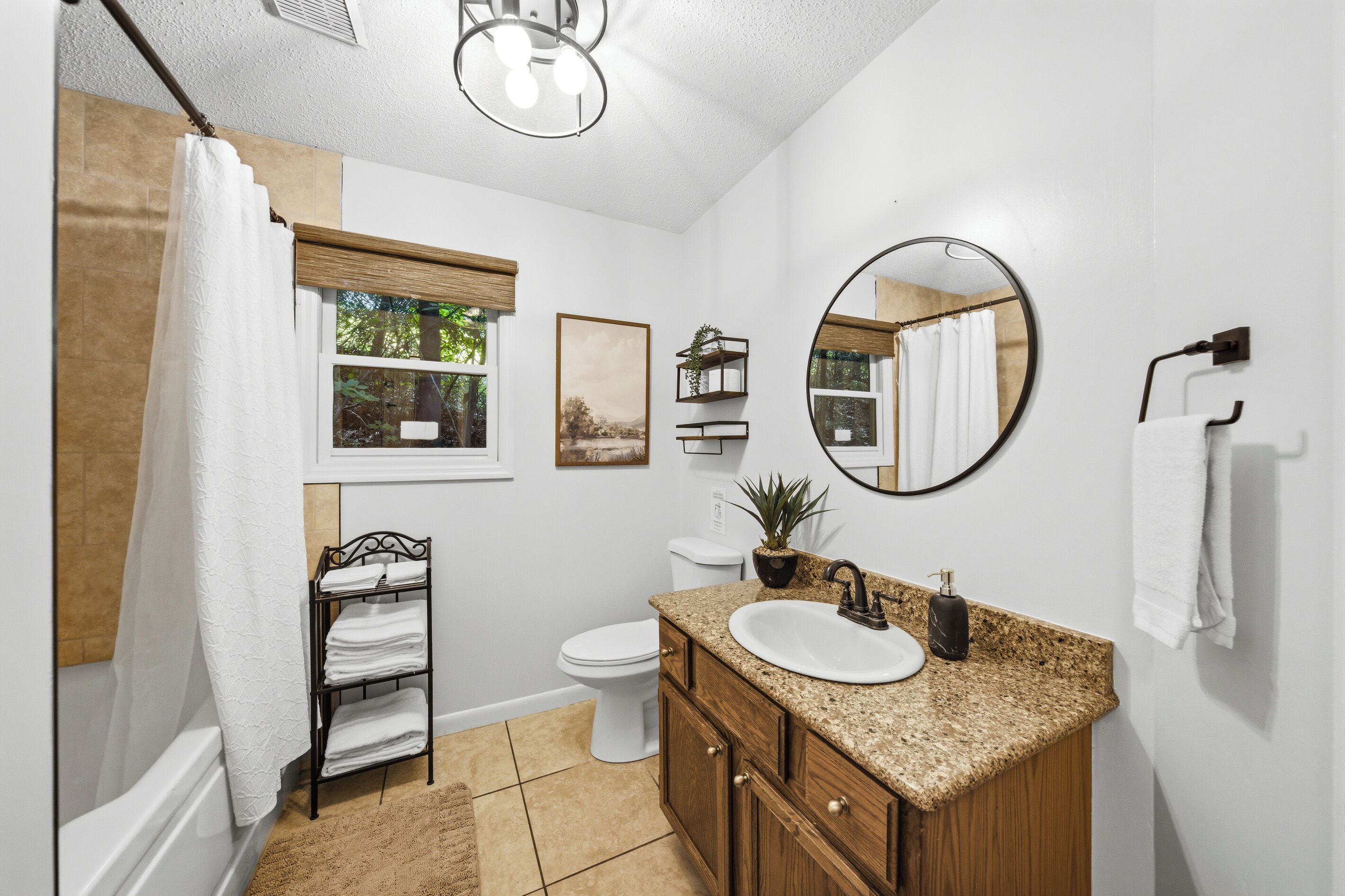 A bathroom with a bathtub, toilet, sink, and a mirror.