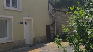 Un edifici amb un camí de grava, una porta blanca i una xemeneia.